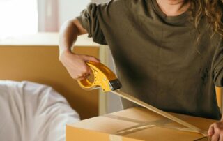 Lady Taping a box closed